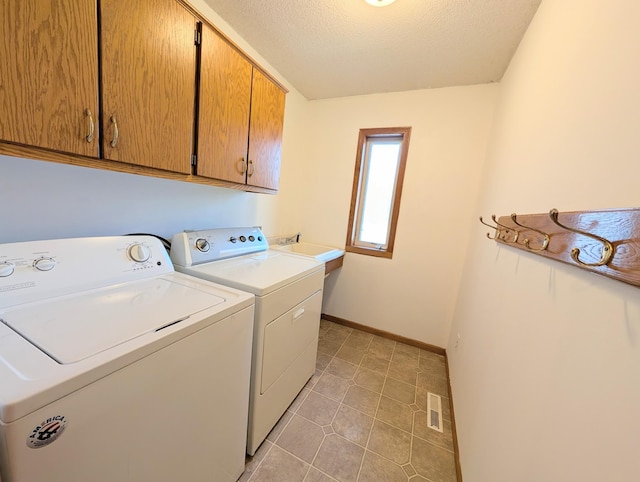 washroom with visible vents, baseboards, separate washer and dryer, cabinet space, and a textured ceiling