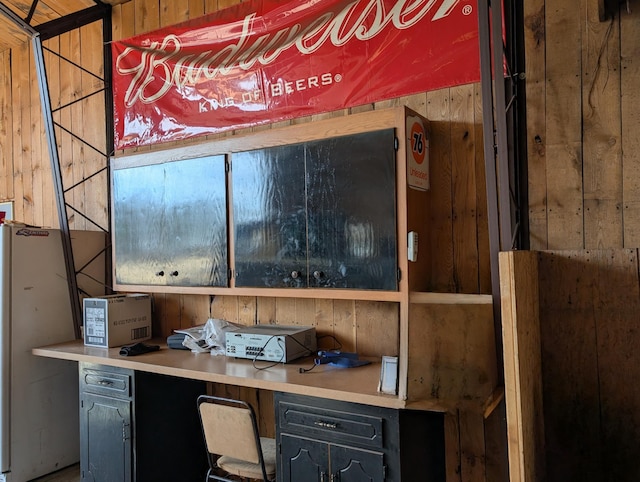 details featuring wood walls and freestanding refrigerator