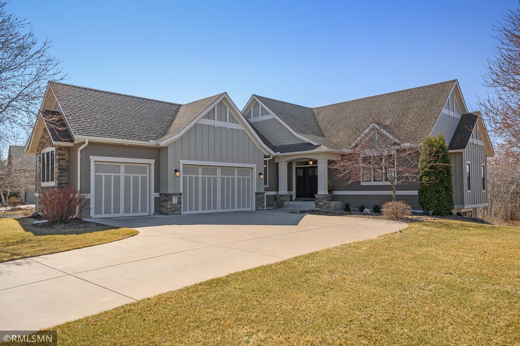 2 Osprey Ct, North Oaks, MN 55127 - craftsman-style home with driveway, board and batten siding, stone siding, an attached garage, and a front lawn