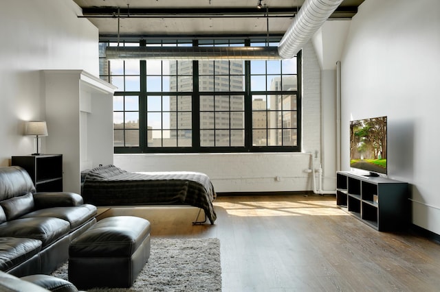 bedroom with a towering ceiling and hardwood / wood-style floors