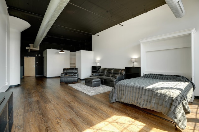 bedroom with hardwood / wood-style floors and a high ceiling