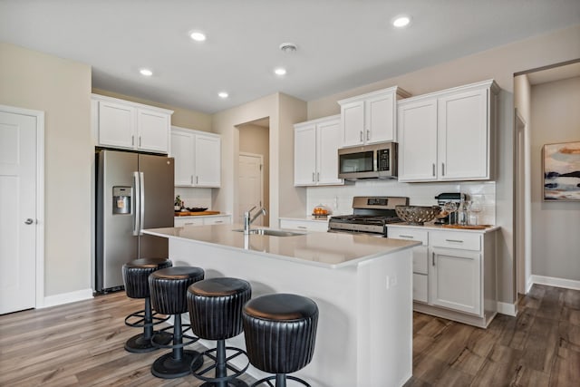 kitchen featuring sink, an island with sink, white cabinets, and appliances with stainless steel finishes