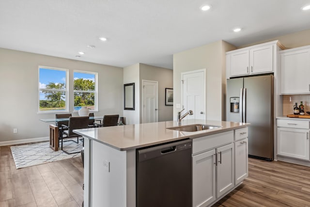 kitchen with dishwashing machine, sink, white cabinetry, and stainless steel refrigerator with ice dispenser