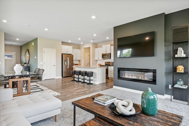 living room with sink and light hardwood / wood-style floors