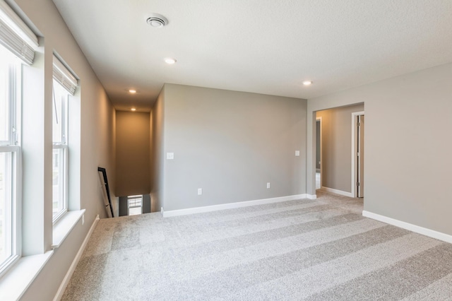 unfurnished room featuring recessed lighting, carpet, visible vents, and baseboards