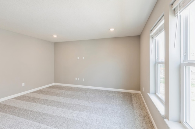 empty room with carpet floors, recessed lighting, and baseboards