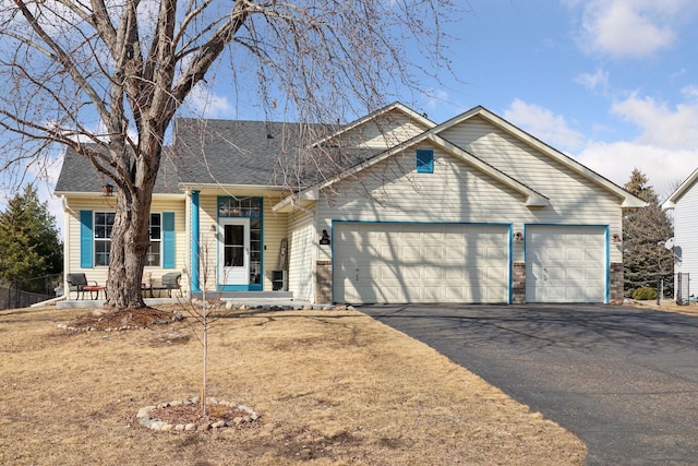 single story home with aphalt driveway, roof with shingles, covered porch, and an attached garage