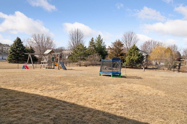 view of jungle gym featuring a yard, a trampoline, and fence