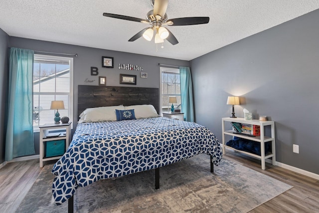 bedroom featuring baseboards, a textured ceiling, wood finished floors, and a ceiling fan