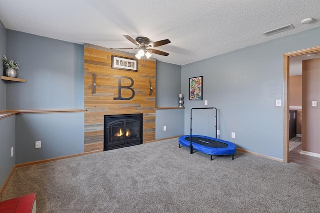 unfurnished room featuring visible vents, a fireplace, carpet, and ceiling fan