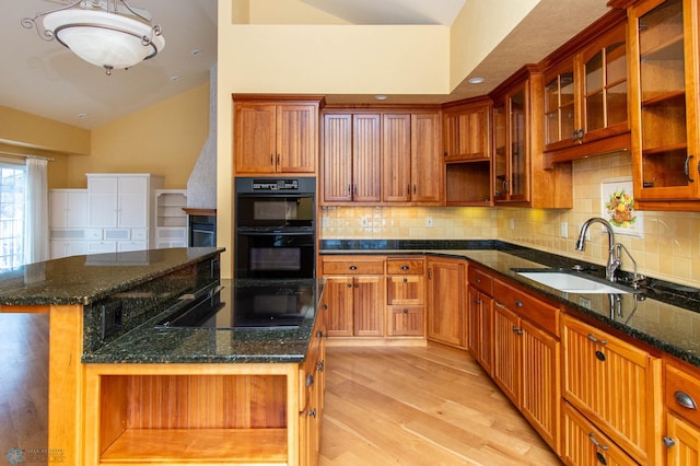 kitchen featuring sink, black appliances, a center island, and dark stone counters