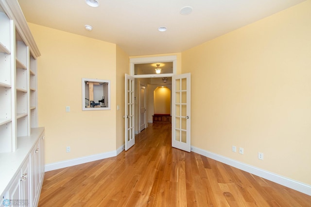 hallway featuring light hardwood / wood-style floors and french doors