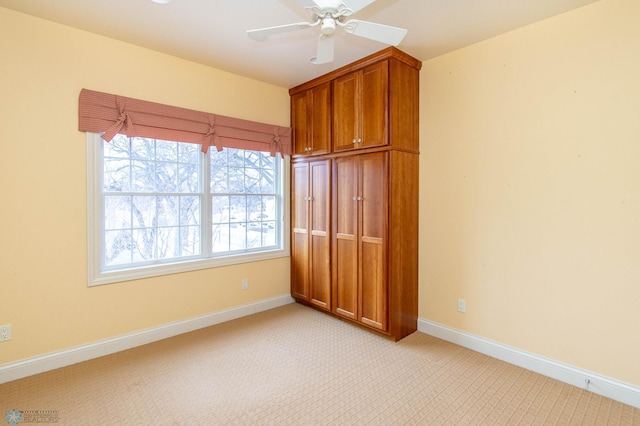 unfurnished bedroom with ceiling fan and light colored carpet