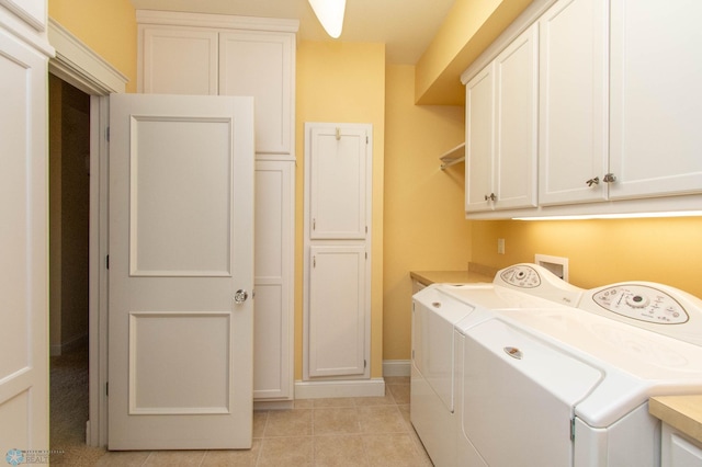 clothes washing area featuring independent washer and dryer, light tile patterned floors, and cabinets