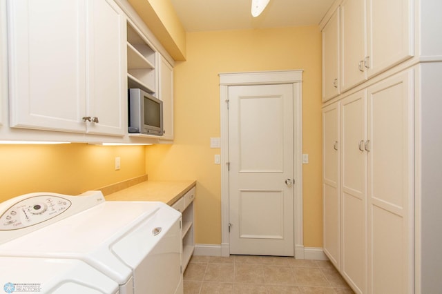 washroom featuring cabinets, light tile patterned floors, and washer and clothes dryer