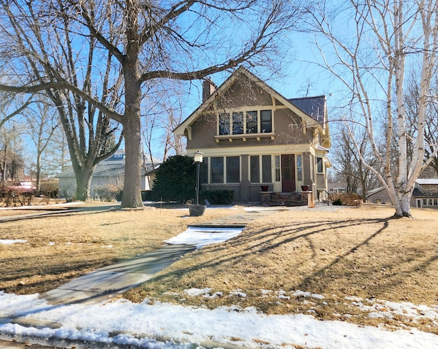 view of front of house with a chimney and stucco siding