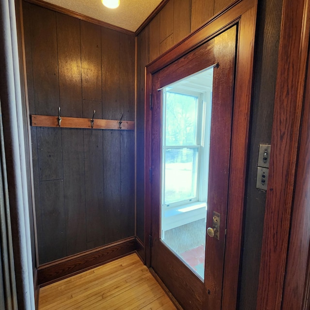 entryway with wood walls and light wood finished floors