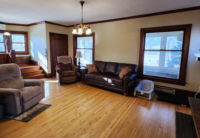 living area featuring a chandelier, light wood-style flooring, a baseboard heating unit, ornamental molding, and stairway