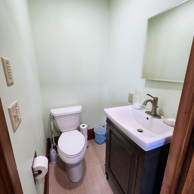 half bath with tile patterned flooring, vanity, and toilet