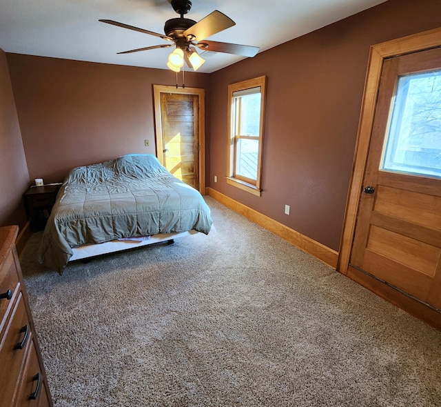 carpeted bedroom with ceiling fan and baseboards