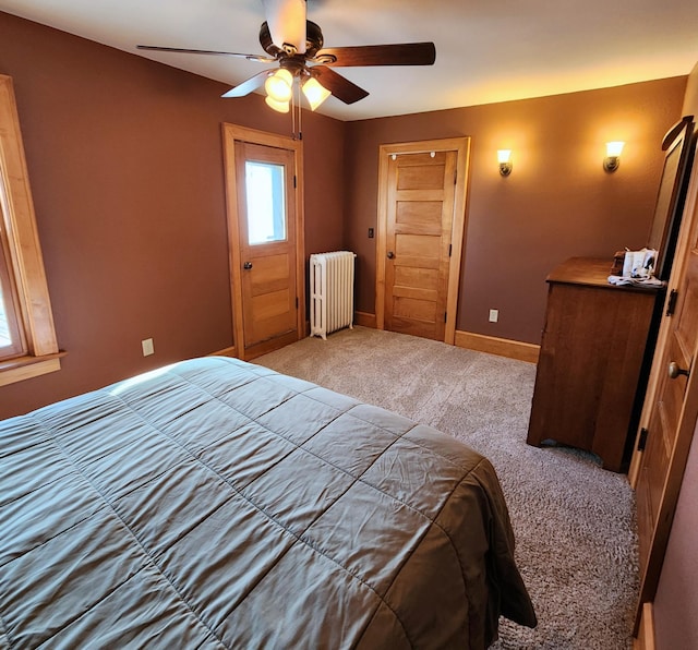 carpeted bedroom with radiator, ceiling fan, and baseboards