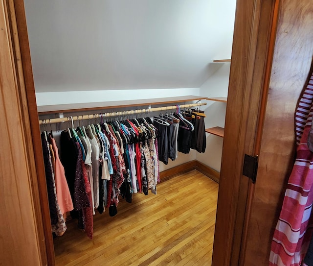 spacious closet featuring lofted ceiling and hardwood / wood-style flooring