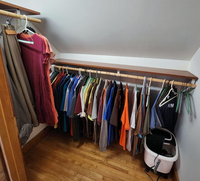 walk in closet featuring lofted ceiling and hardwood / wood-style flooring