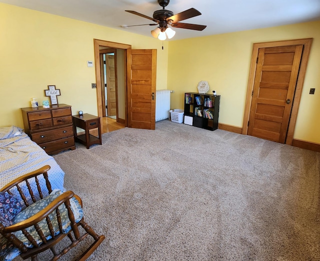 bedroom with a ceiling fan, carpet, radiator, and baseboards