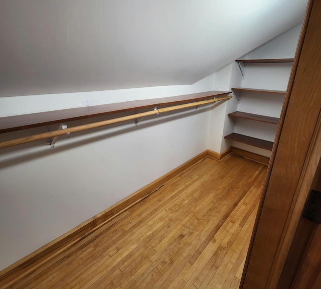 walk in closet featuring lofted ceiling and light wood finished floors