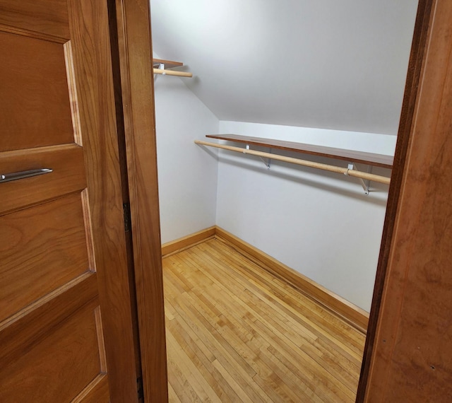 spacious closet featuring lofted ceiling and wood-type flooring