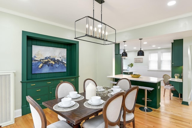 dining room featuring crown molding, a notable chandelier, and light hardwood / wood-style flooring