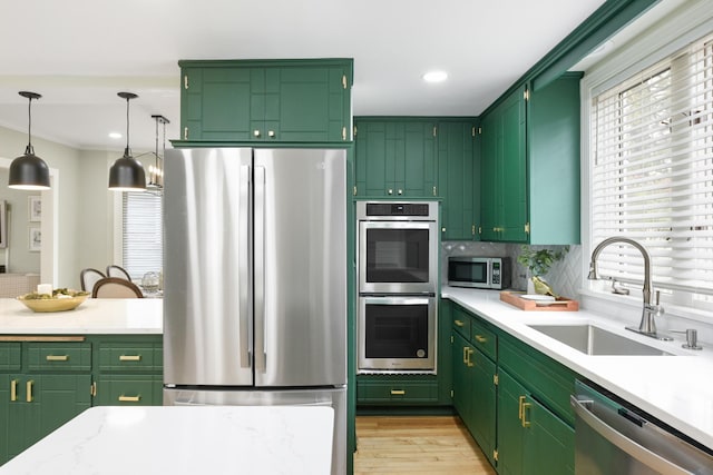 kitchen with sink, a wealth of natural light, stainless steel appliances, and green cabinets