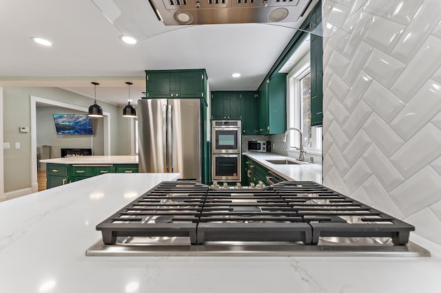 kitchen featuring sink, tasteful backsplash, green cabinetry, light stone counters, and stainless steel appliances