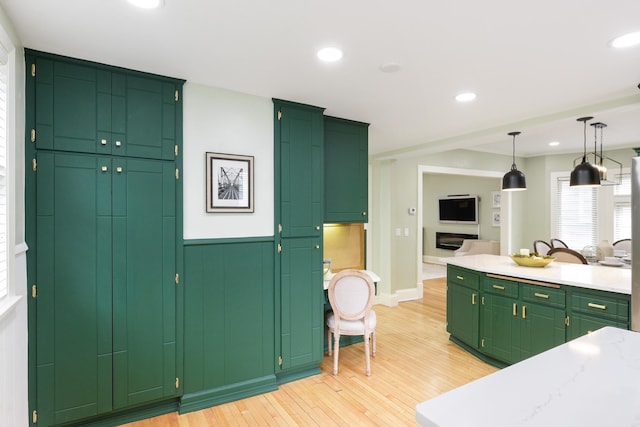 kitchen featuring pendant lighting, light hardwood / wood-style floors, and green cabinetry