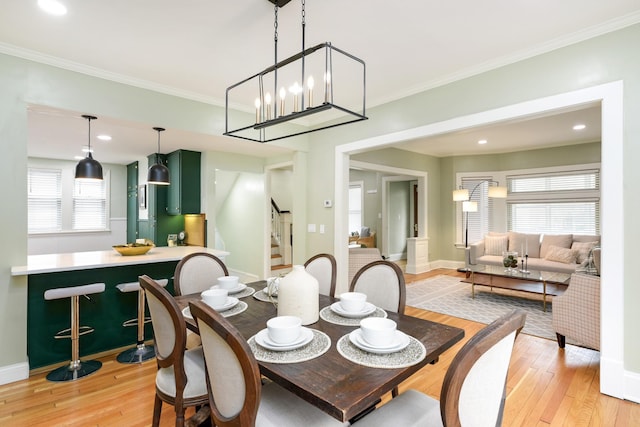 dining space with light hardwood / wood-style flooring and ornamental molding