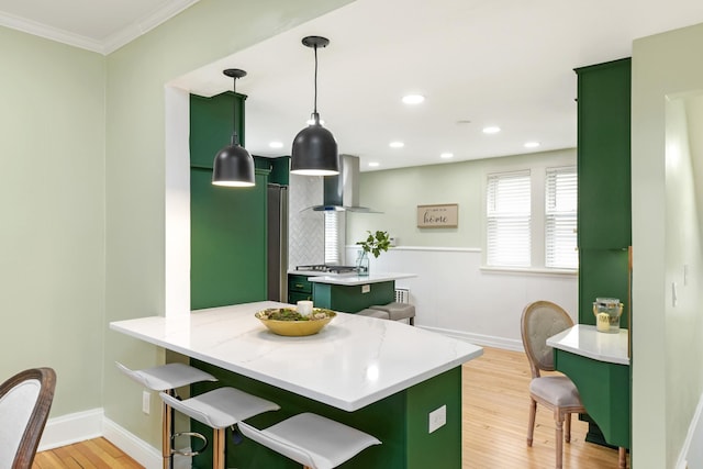 kitchen featuring exhaust hood, a kitchen island, a breakfast bar, and pendant lighting