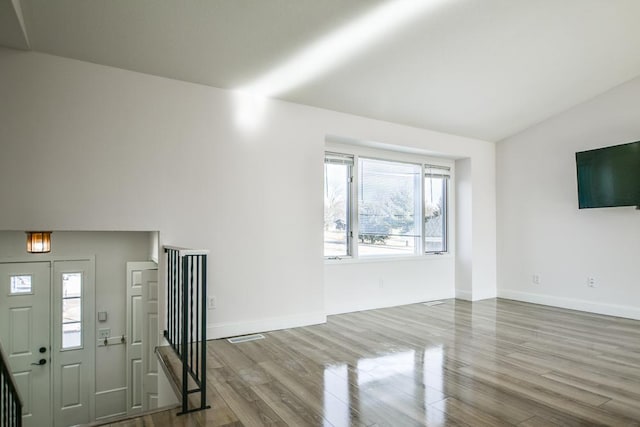 entryway featuring hardwood / wood-style flooring and vaulted ceiling