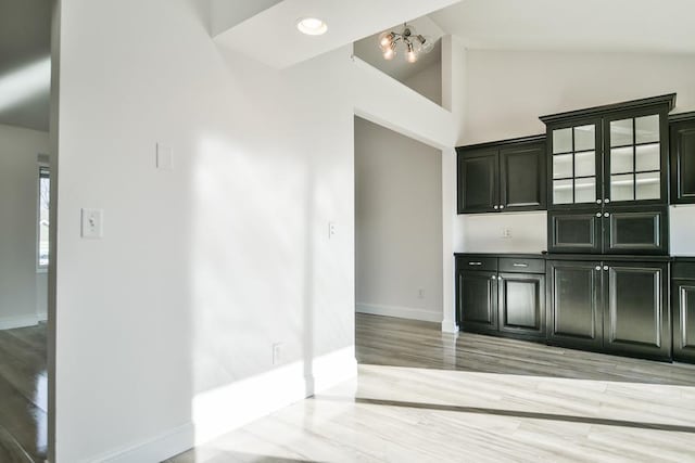 kitchen featuring high vaulted ceiling, an inviting chandelier, and light wood-type flooring