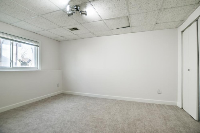 spare room with a drop ceiling and carpet