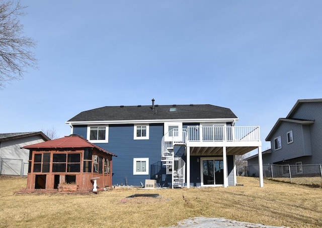 rear view of property featuring a yard, a gazebo, and a wooden deck