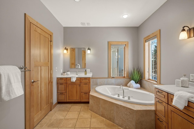 bathroom featuring tile patterned floors, vanity, and tiled tub