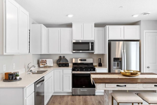 kitchen featuring light countertops, a sink, white cabinetry, and appliances with stainless steel finishes