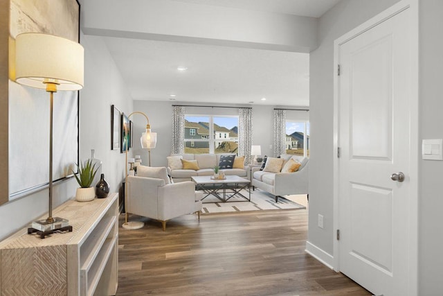 living area featuring baseboards, wood finished floors, and recessed lighting