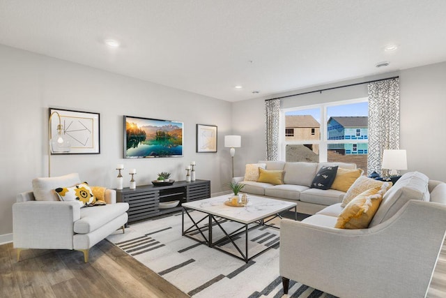 living area with baseboards, light wood-style floors, and recessed lighting