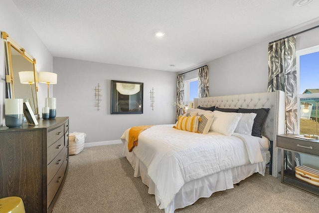 bedroom with light colored carpet, baseboards, and multiple windows