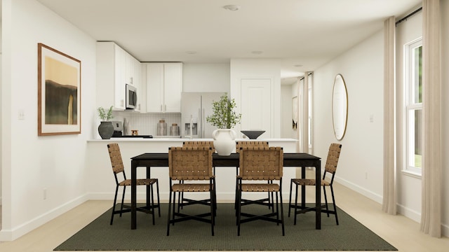 kitchen with white cabinetry, refrigerator with ice dispenser, and decorative backsplash