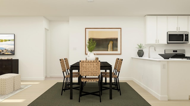 dining area with sink and light wood-type flooring