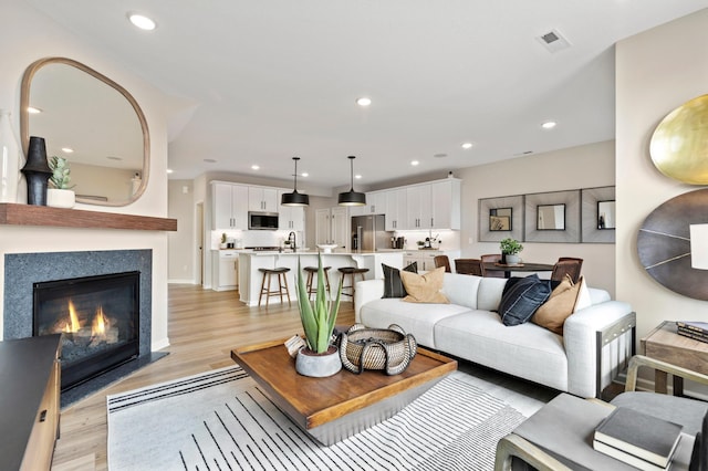 living room featuring sink and light wood-type flooring