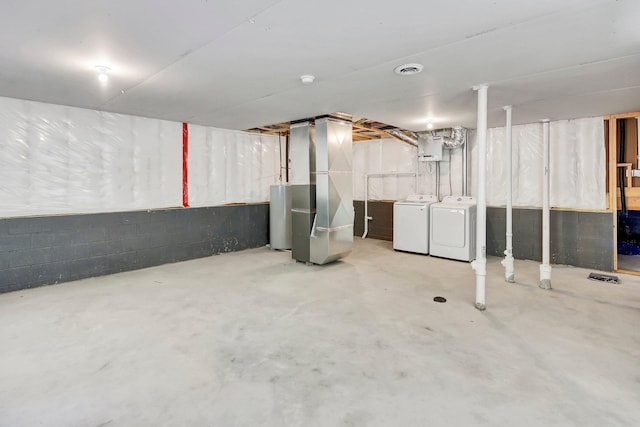 basement with heating unit and separate washer and dryer