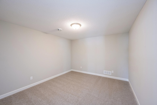 carpeted spare room with a textured ceiling